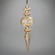 Borostyánsárga, áttetsző üveg karácsonyfadísz, elegáns, csepp alakú formában, kézműves kivitelben.