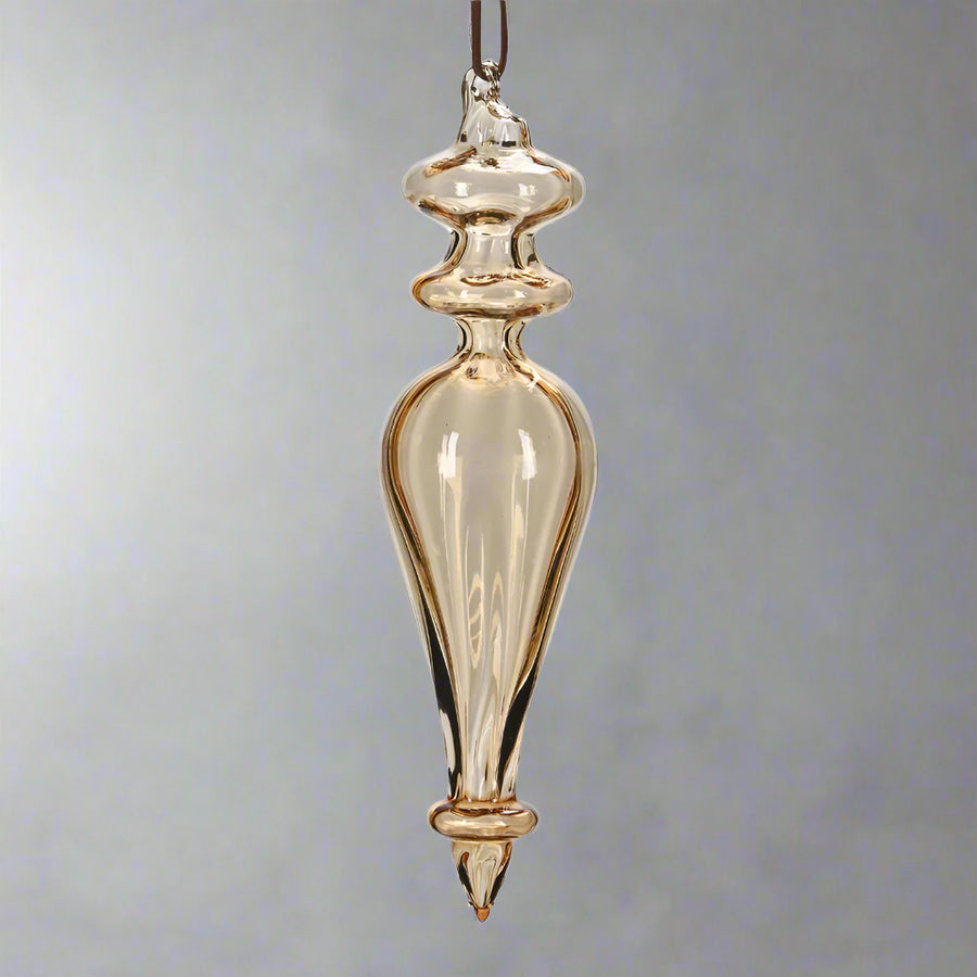 Hosszúkás, kézzel fújt, megcsavart formájú borostyánsárga üveg jégcsap dísz, fényes felülettel.