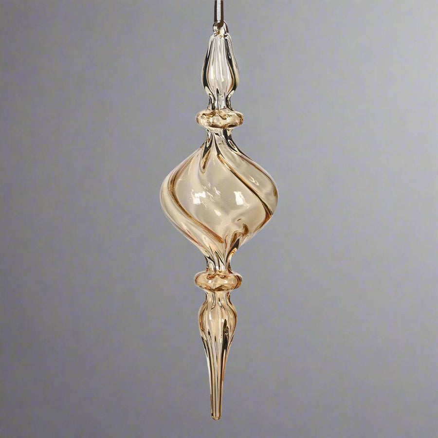 Modern, mégis klasszikus megjelenésű borostyánsárga üveg karácsonyfadísz, elegáns csavart formában.