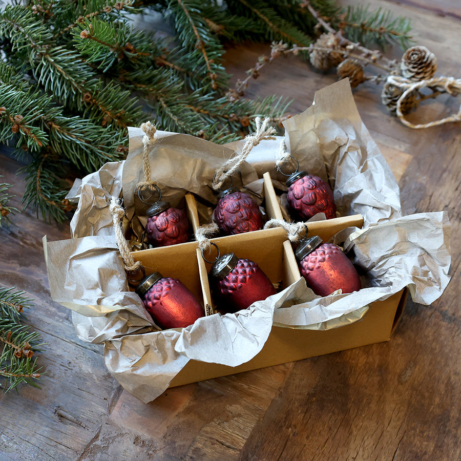 Vintage stílusú antik meggybordó karácsonyfadíszek díszdobozban, rusztikus papírral és fenyőágakkal