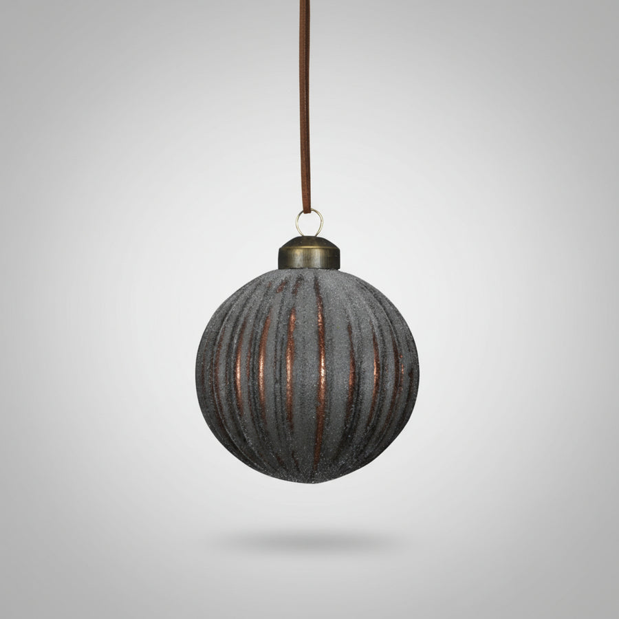 Barázdált mintájú, bronzbarna Antique üveg karácsonyfadísz közelről, selyem szalaggal felfüggesztve.