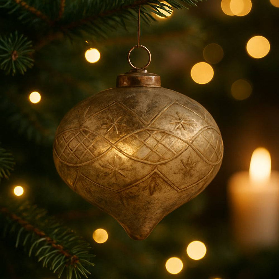 Ezüst-rozsda patinás, metszett mintás Antique üvegdísz fenyőágon, gyertyafényes karácsonyi háttérrel