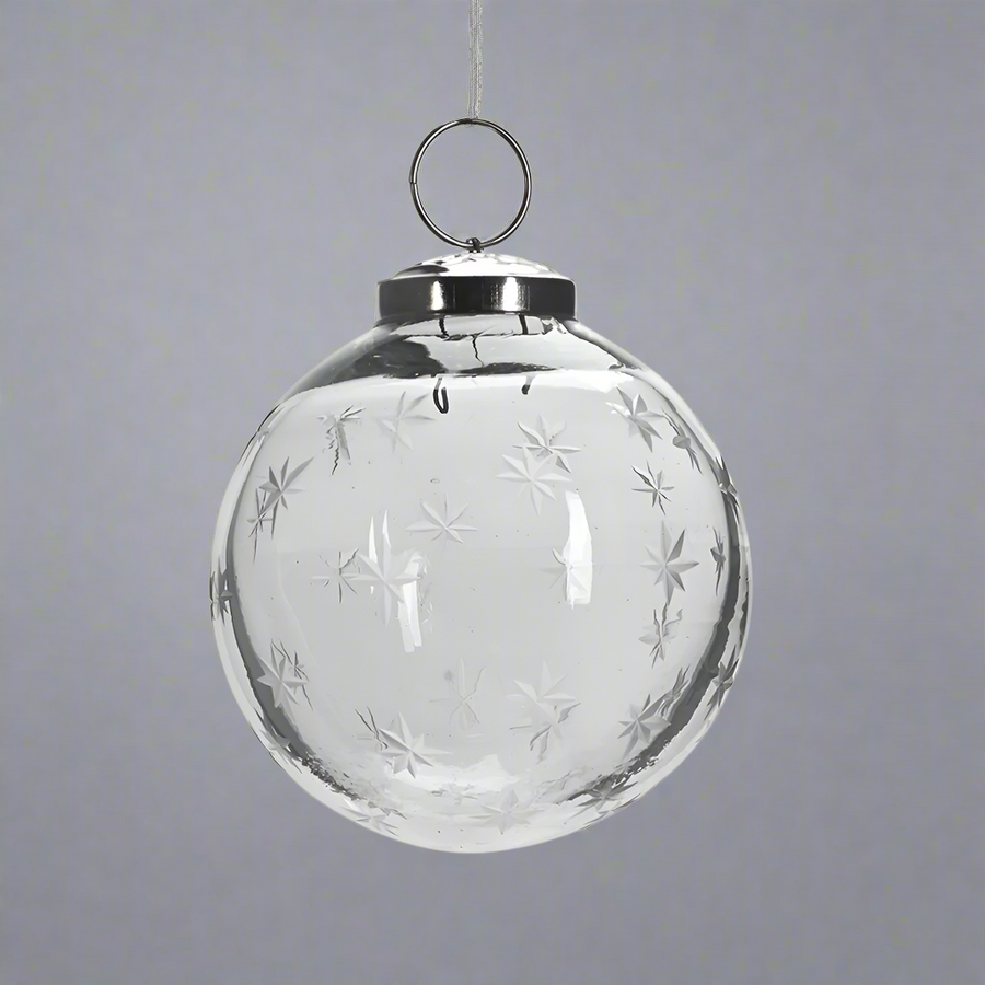 Áttetsző, 8 cm-es üveggömb karácsonyfadísz finoman maratott hópehely mintákkal, ezüst akasztóval.
