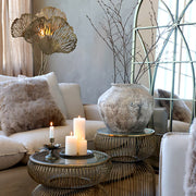 Krémszínű antik váza letisztult nappali enteriőrben, üvegasztalon elhelyezve.