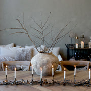 Antik váza száraz ágakkal skandináv stílusú étkezőasztalon.