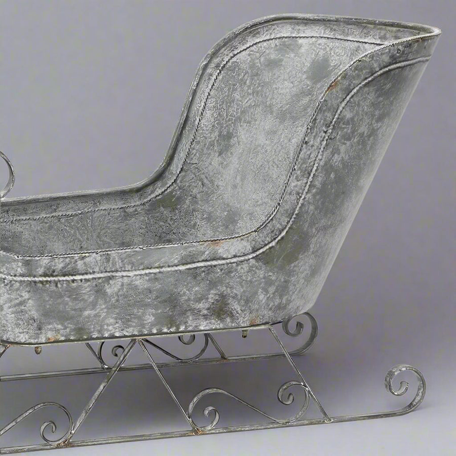 Karácsonyi fém szán hátsó részlete közelről, textúrált, antikolt felülettel.