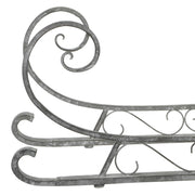 Fém dekor szán elülső részlete ívelt csővázzal, patinás felülettel és díszes vonalvezetéssel.