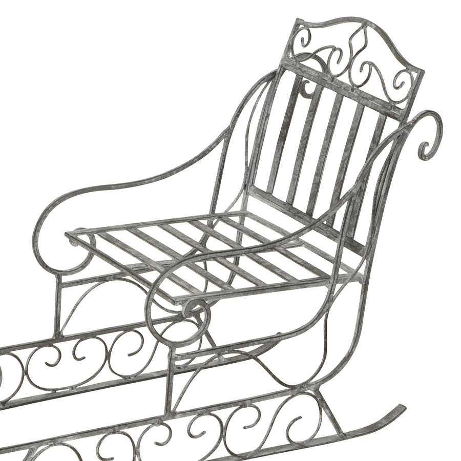 Dekoratív karácsonyi szán fém ülőfelülete és ívelt háttámlája, klasszikus vidéki stílusban.