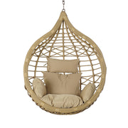 Aurora Nest natúr műrattan kerti függőfotel bézs színű párnákkal, szemből fotózva, fehér háttér előtt.