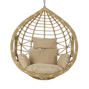 Aurora Nest natúr műrattan kerti függőfotel bézs színű párnákkal, szemből fotózva, fehér háttér előtt.