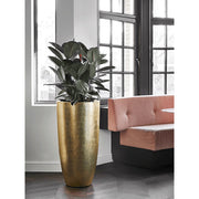 Nagy méretű aranyszínű kaspó világos étkező sarokban, sötétzöld növénnyel