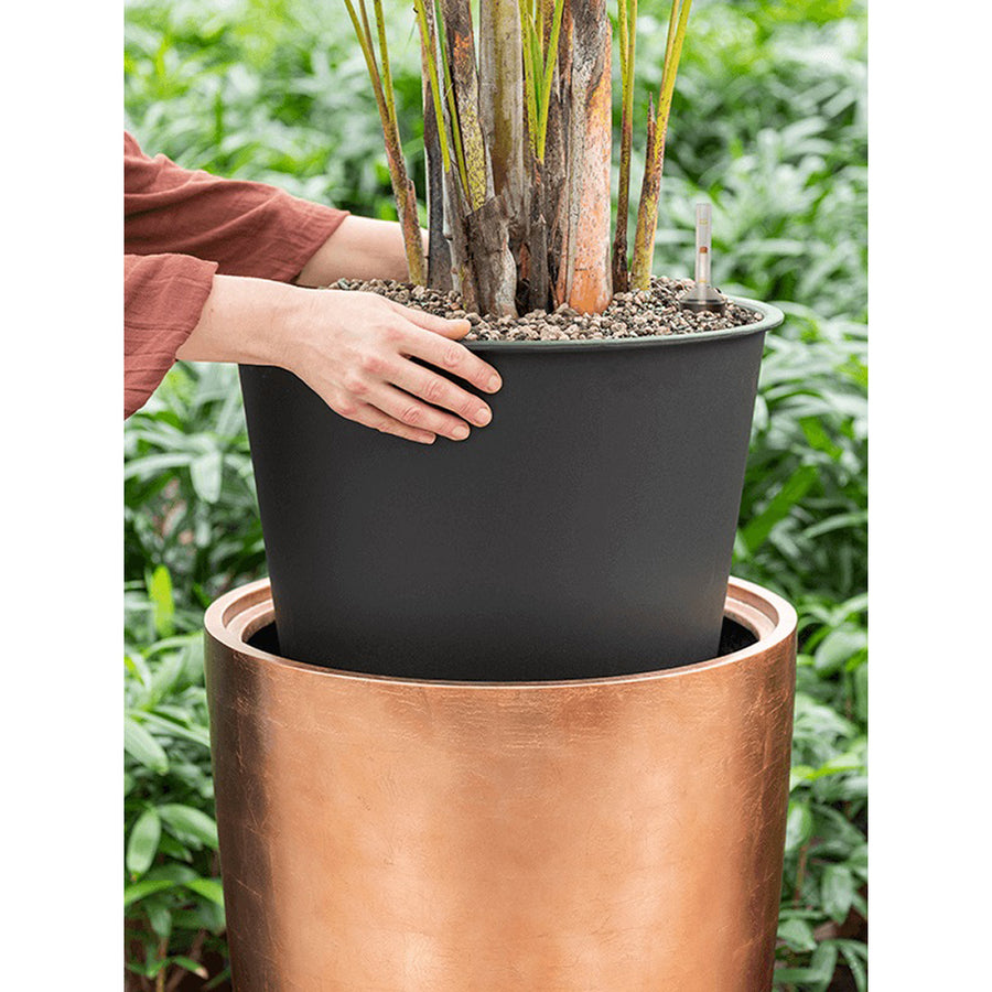 Közelkép növény beültetéséről a BAQ Partner matt réz kaspóba, integrált belső cseréppel.