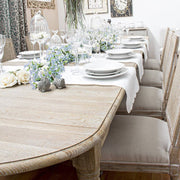 Bedford natúr tölgyfa étkezőasztal terített asztallappal, fehér virágdíszekkel és elegáns asztali dekorációval.
