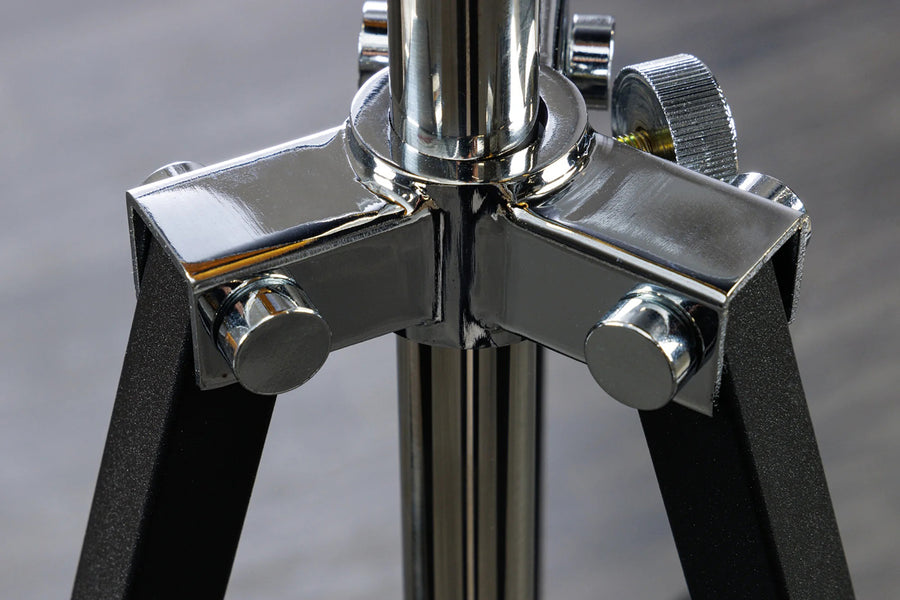 Háromlábú, aranyszínű design állólámpa.