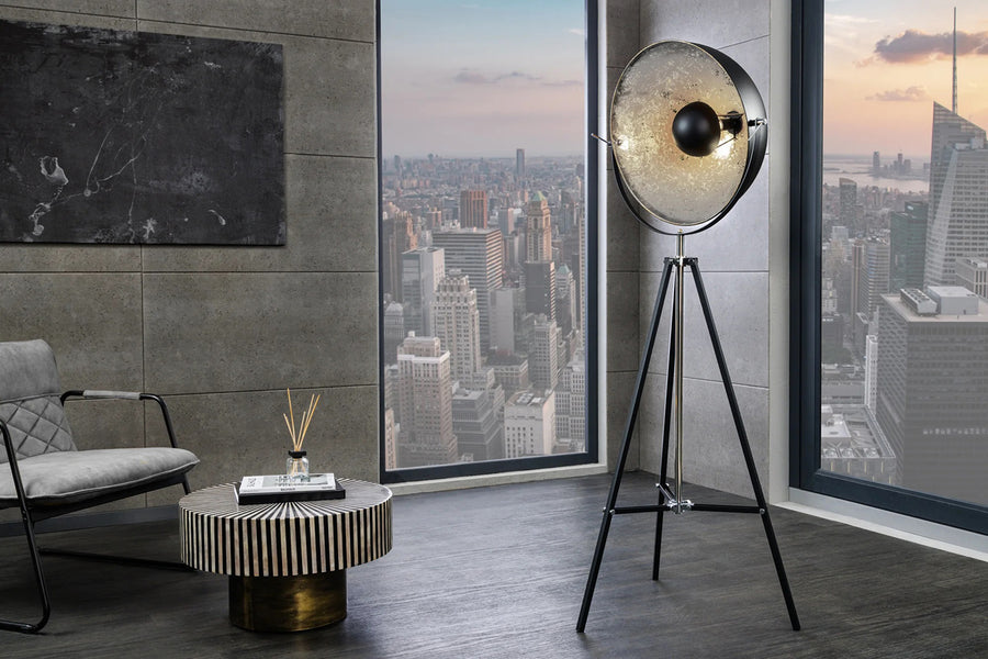 Háromlábú, ezüstszínű design állólámpa.