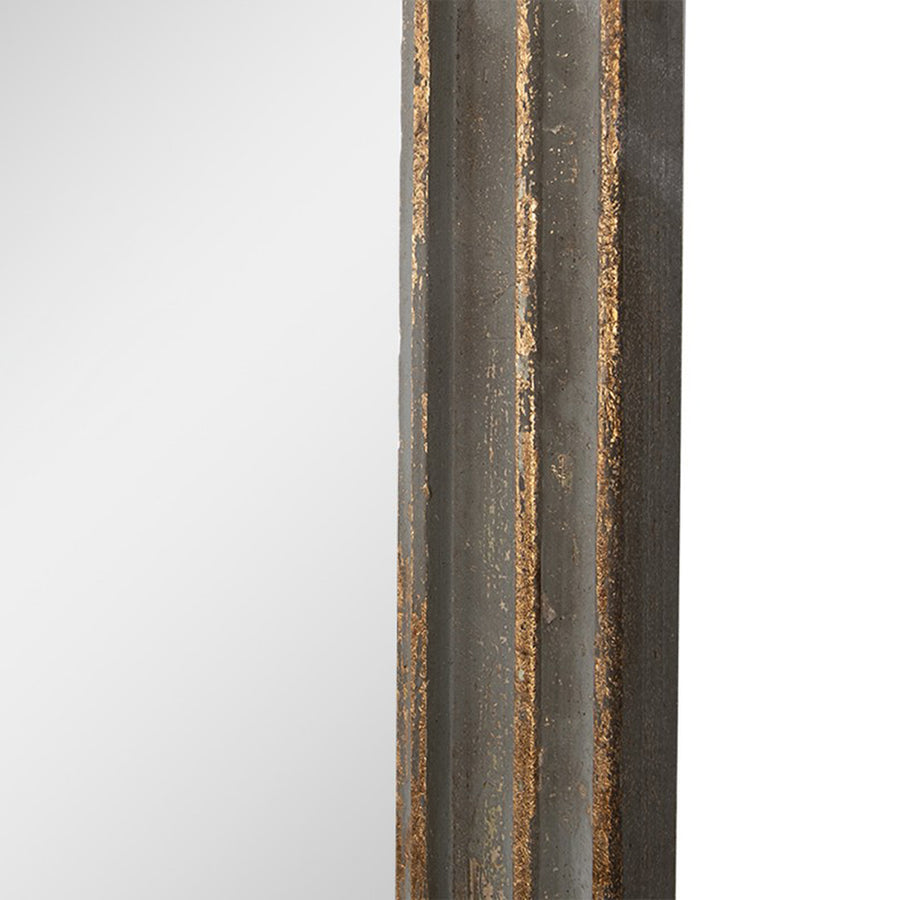 Közelkép a falitükör arany patinázott fakeretének részletéről.