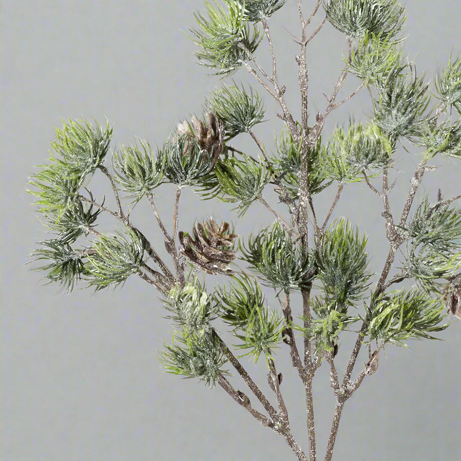 Jeges, glitteres felületű, tobozokkal díszített mű cédrusfenyő ág.