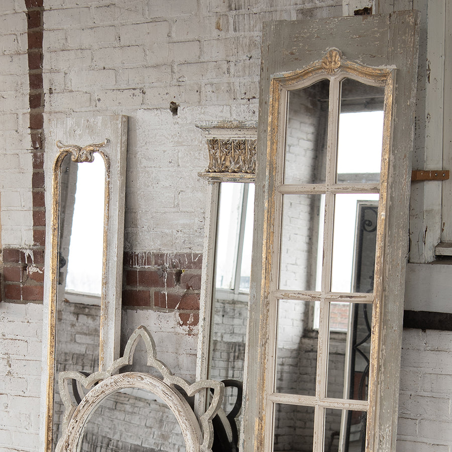 Rusztikus térben elhelyezett vintage falitükör több antik tükörrel együtt.