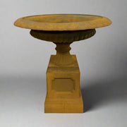 Antikolt felületű öntöttvas kaspó posztamensen, oldalsó nézetben, Château Jardin kollekció, klasszikus kerti dekorációként.