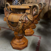 Antikolt öntöttvas kerti díszvázák sorban, hattyúfejes fogantyúval és virágfüzérrel, Château Jardin kollekció, raktári környezetben.