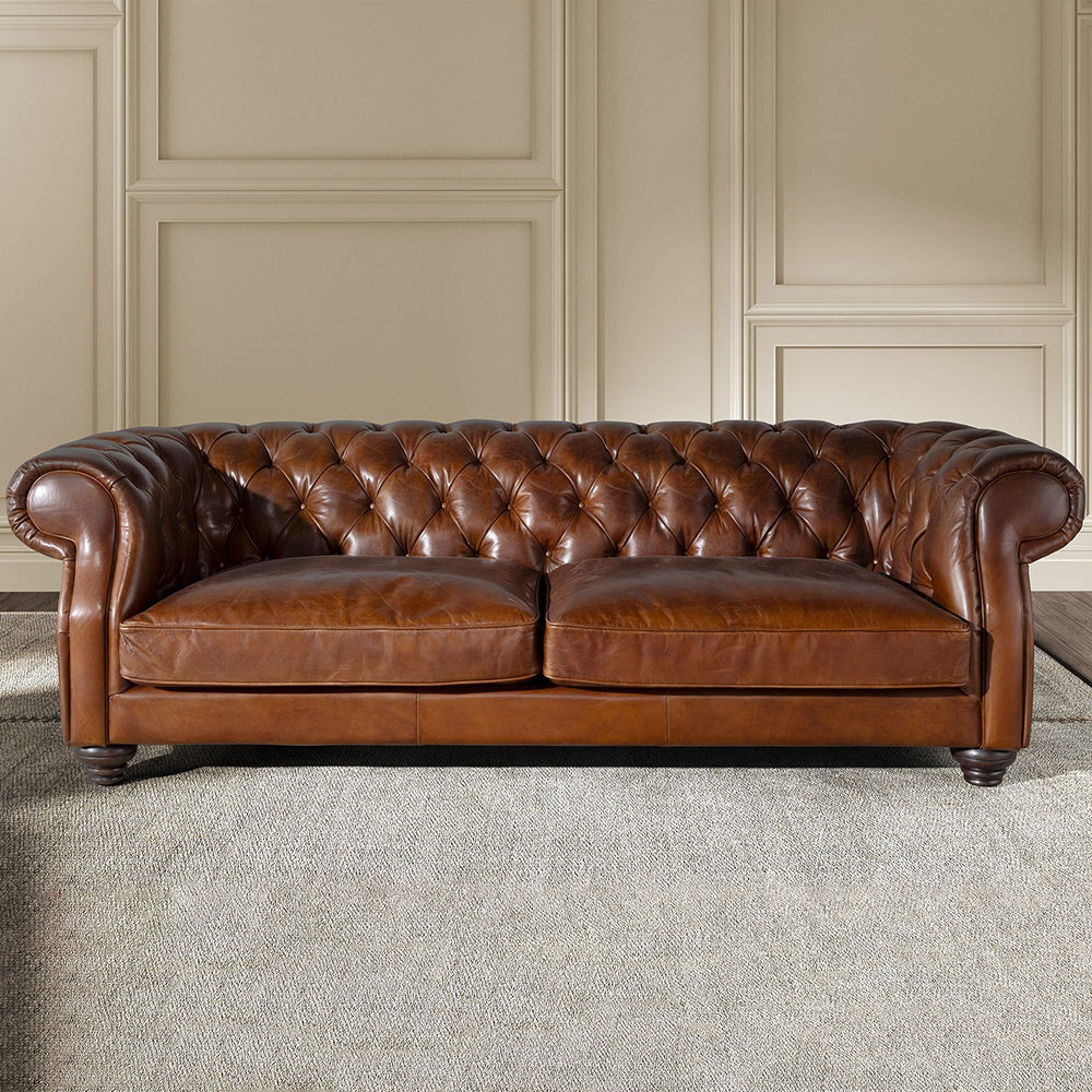 Chesterfield stílusú, háromszemélyes konyakbarna bőrkanapé.