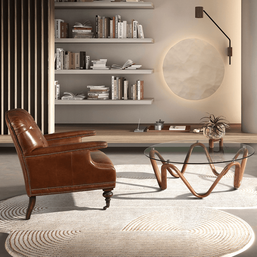 Enteriőr oldalnézet – Chester bőrfotel üvegasztal és könyvespolc mellett.