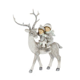 FIRST SNOW krémezüst karácsonyi szarvas figura 19 cm, hátán két téli ruhás gyermekkel és mentazöld részletekkel.