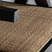 Rattan ülőfelület közelről, fekete fakeretben.