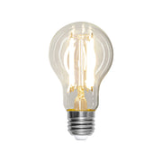 Tiszta üvegű, melegfehér fényű LED izzó E27-es foglalattal, A60-as formával, 4 szálas filament kialakítással, világítás közben.