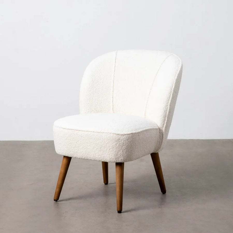 CLUB EMMA fotel modern térben, világos bouclé kárpittal és fa lábakkal.