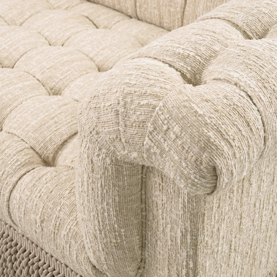 Krémszínű buklészövettel kárpitozott, 3 személyes kanapé.