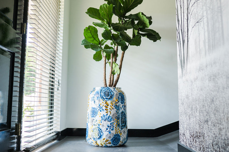 Dutch Blue fém kaspó sarokban elhelyezve nagy növénnyel – kézzel festett beltéri design darab elegáns térben