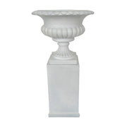 Fehér kaspó tál posztamensre helyezve, klasszikus dekorációs elrendezésben.