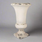 Klasszikus vonalvezetésű krémszínű kaspó szemből, semleges háttérrel