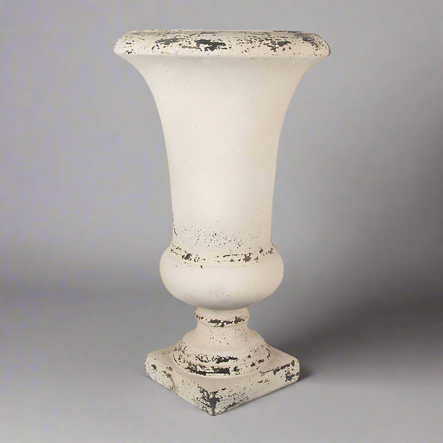 Klasszikus vonalvezetésű krémszínű kaspó szemből, semleges háttérrel