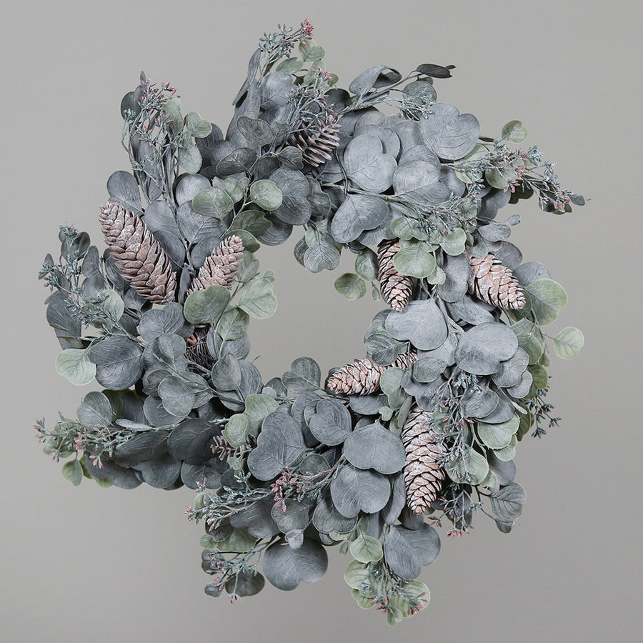 Ünnepi dekorációra készült, élethű eukaliptusz koszorú deres hatással és természetes toboz díszítéssel.