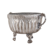 Ezüstszínű, dombormintával díszített, lábakon álló fém kaspó tál.