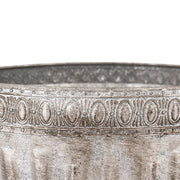 Ezüstszínű, dombormintával díszített, lábakon álló fém kaspó tál.