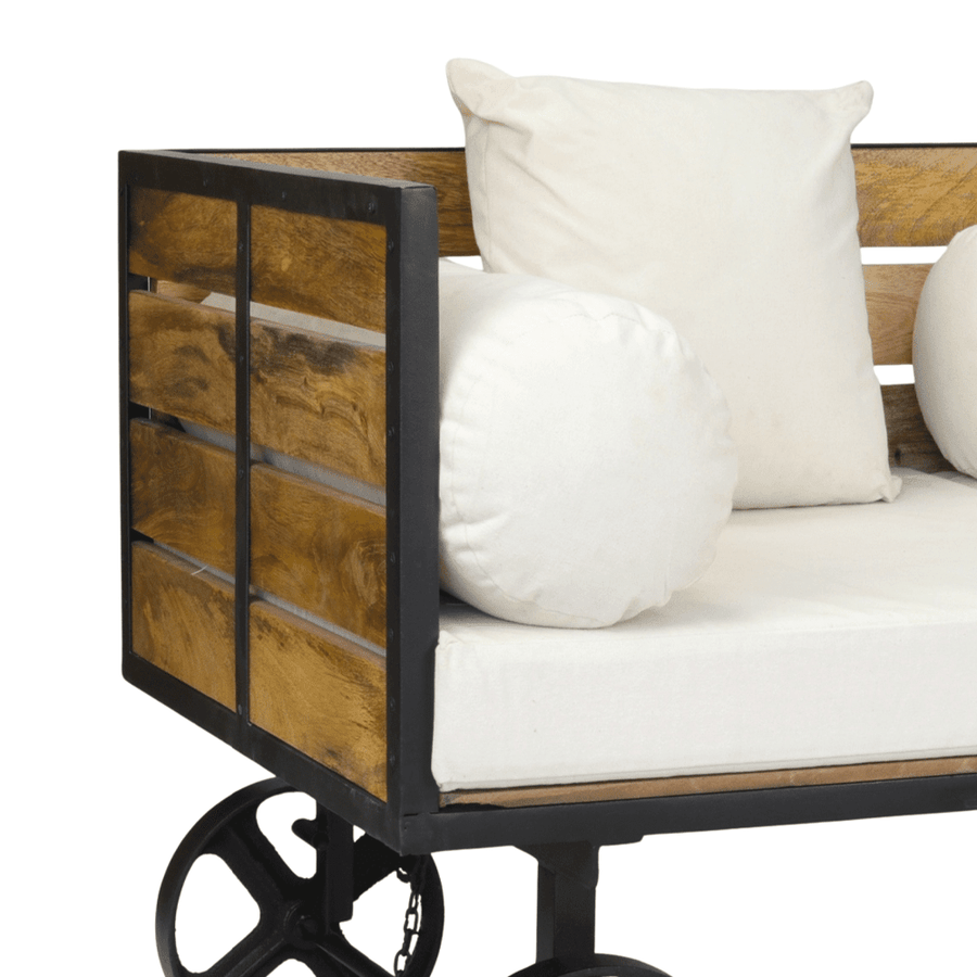 Részletfotó a FACTORY szekérkanapé fa oldaláról és fehér, hengerpárnával kiegészített ülőfelületéről.