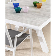 Krém színű kortárs kerti étkezőasztal színes üveg poharakkal.