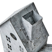 Szürke színű, bádogból készült házikókat formázó lámpás.