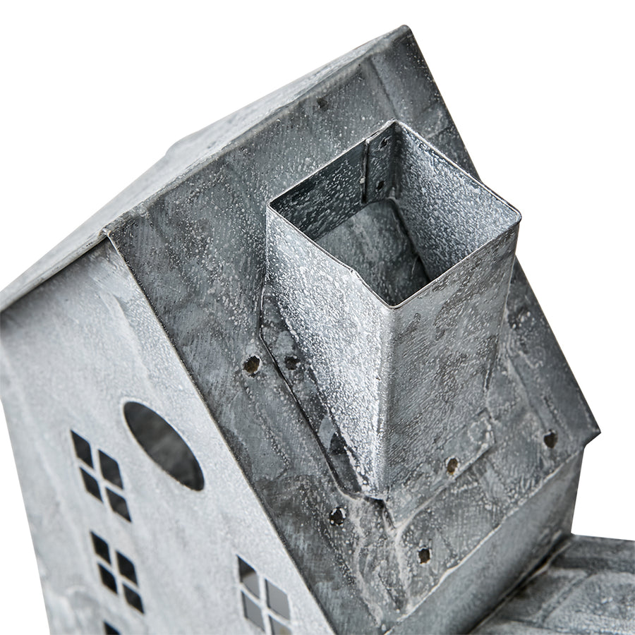 Szürke színű, bádogból készült házikókat formázó lámpás.