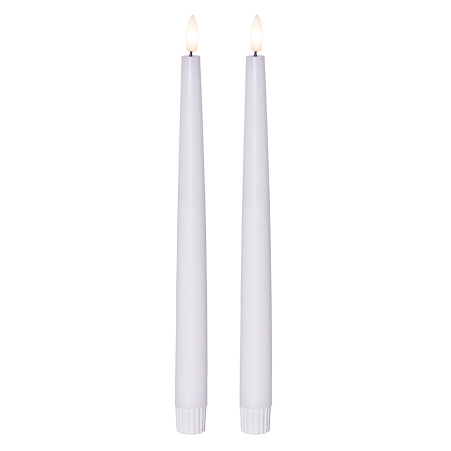 Két darab fehér színű, karcsú LED gyertya égő lánghatással, fehér talppal, fehér háttér előtt.