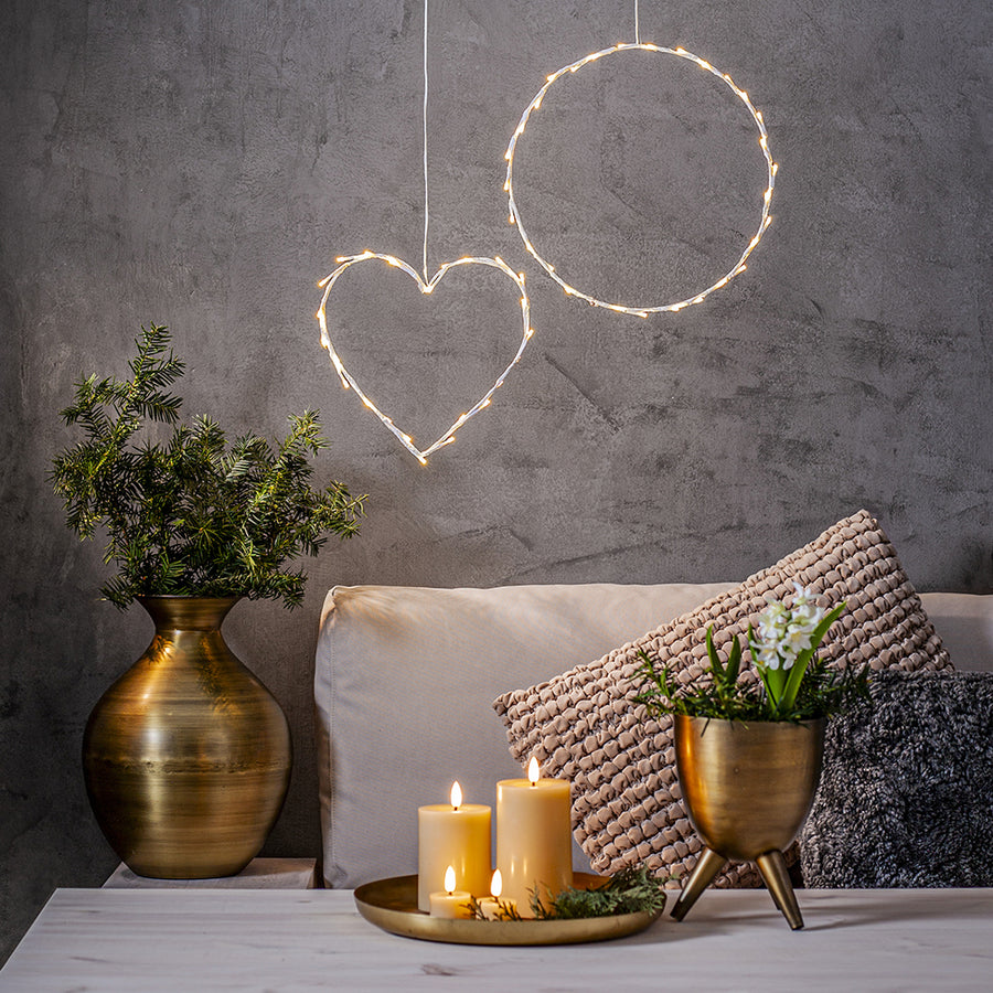 Bézs Flow LED gyertyák tálcán elhelyezve egy modern nappaliban, dekorációs világítással és száraz növényes vázával – meleg, meghitt otthoni hangulat