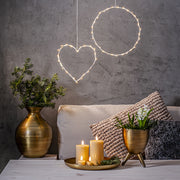 Bézs Flow LED gyertyák tálcán elhelyezve egy modern nappaliban, dekorációs világítással és száraz növényes vázával – meleg, meghitt otthoni hangulat.