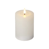 Fehér, henger alakú LED gyertya meleg fényű lánggal, a Star Trading FLOW kollekció 7,5 x 12,5 cm-es, élethű viaszbevonatú változata.