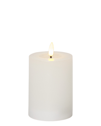 Fehér, henger alakú LED gyertya meleg fényű lánggal, a Star Trading FLOW kollekció 7,5 x 12,5 cm-es, élethű viaszbevonatú változata.