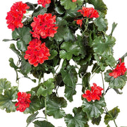 Közelről fotózott piros UV-álló mű muskátli levelekkel és élethű virágokkal