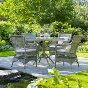 Üveglappal fedett, antikszürke színű, műrattan kerti asztal.