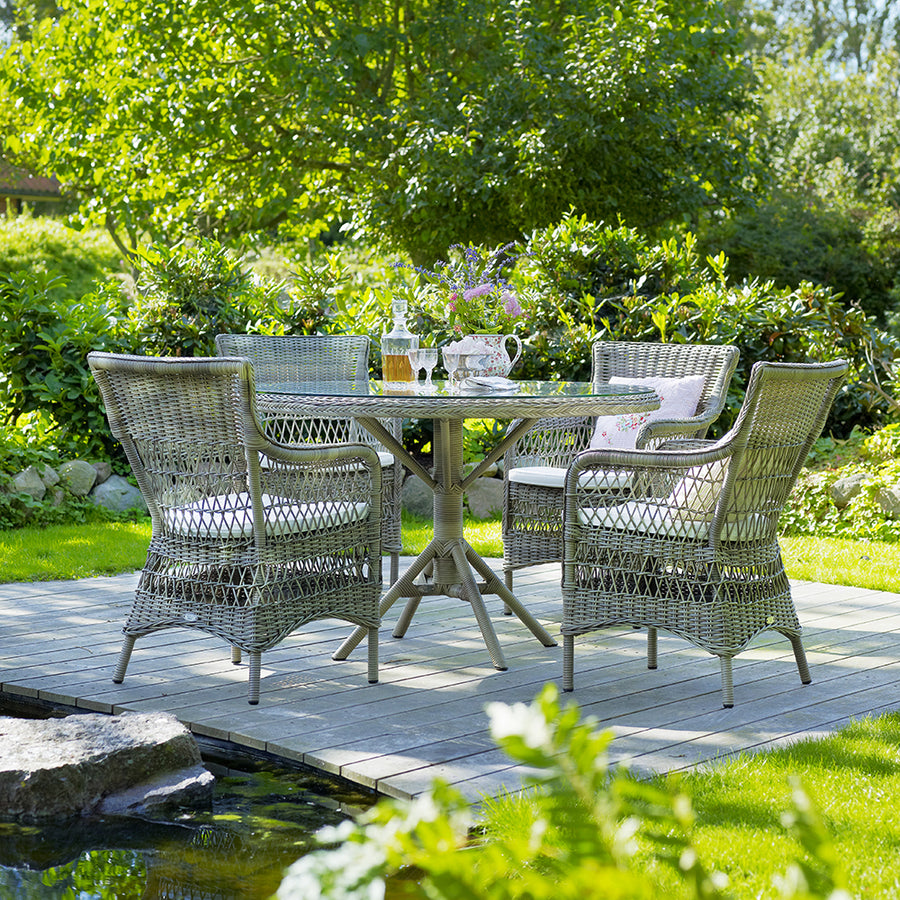 Üveglappal fedett, antikszürke színű, műrattan kerti asztal.